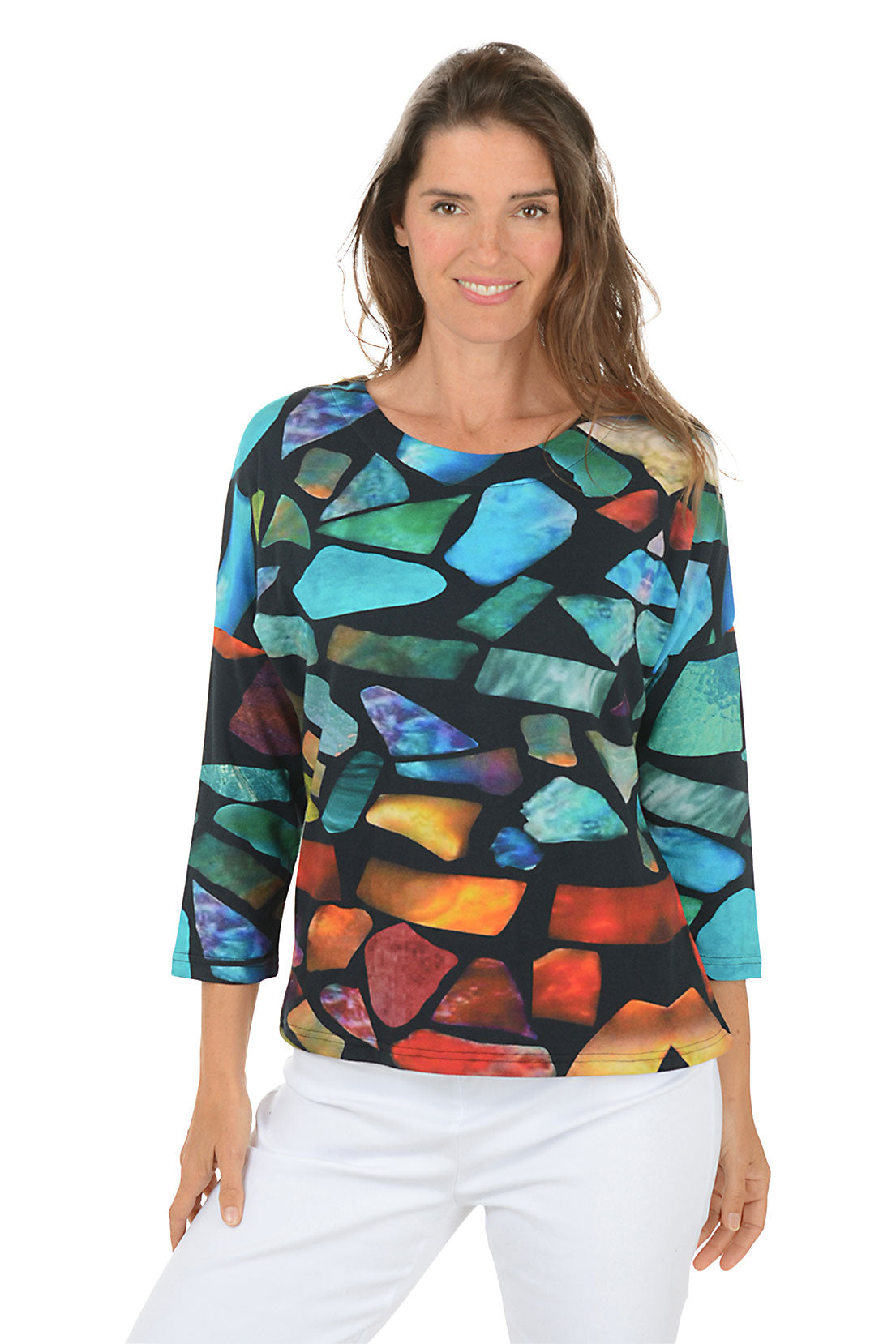 Woman wearing a 3/4 sleeve colorful abstract patterned top on a white background.