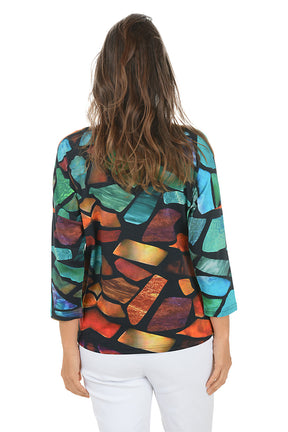 Woman wearing a 3/4 sleeve colorful abstract patterned top on a white background. Back shot.