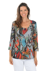 Woman wearing a 3/4 sleeve colorful abstract patterned top on a white background.