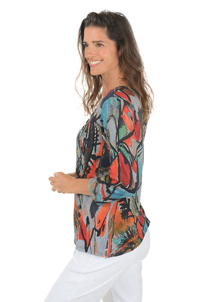Woman wearing a 3/4 sleeve colorful abstract patterned top on a white background. Side shot.