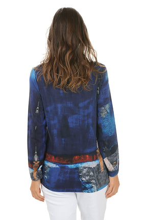 Woman wearing a colorful long-sleeve top with abstract design on a white background. Back shot.