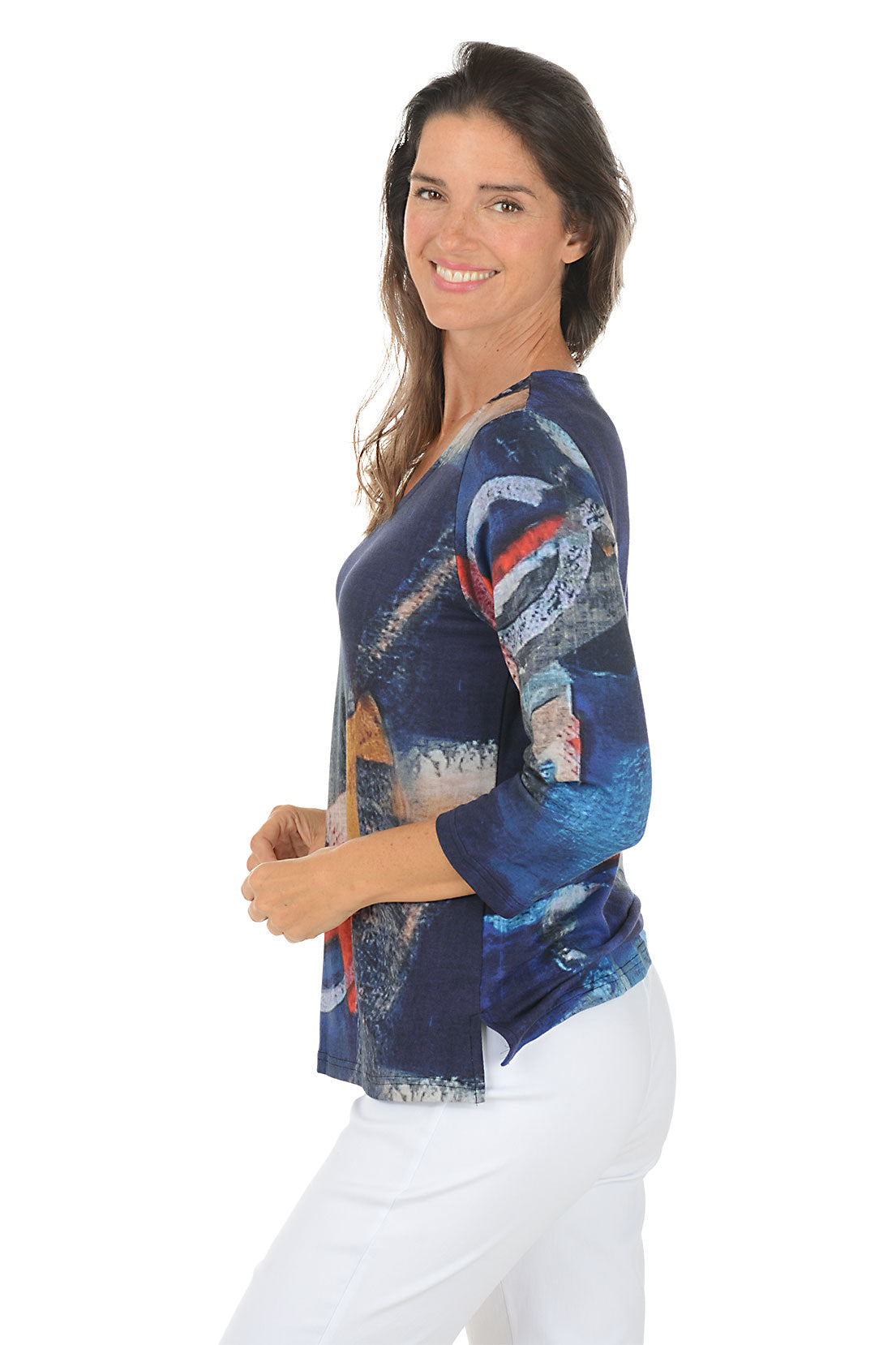 Woman wearing a 3/4 sleeve colorful abstract patterned top on a white background. Side shot.