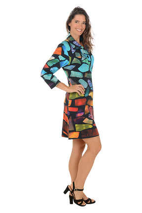 Woman wearing a 3/4 sleeve colorful abstract patterned dress with pockets on a white background. Side shot.
