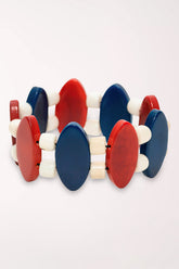 Bracelet with red, white, and blue circular beads on a white background