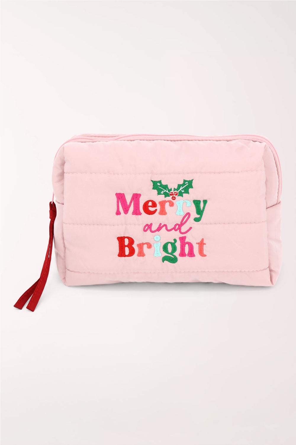 A light pink quilted cosmetics pouch with "Merry and Bright" embroidered in red and pink with holly leaves, and a red zipper pull.