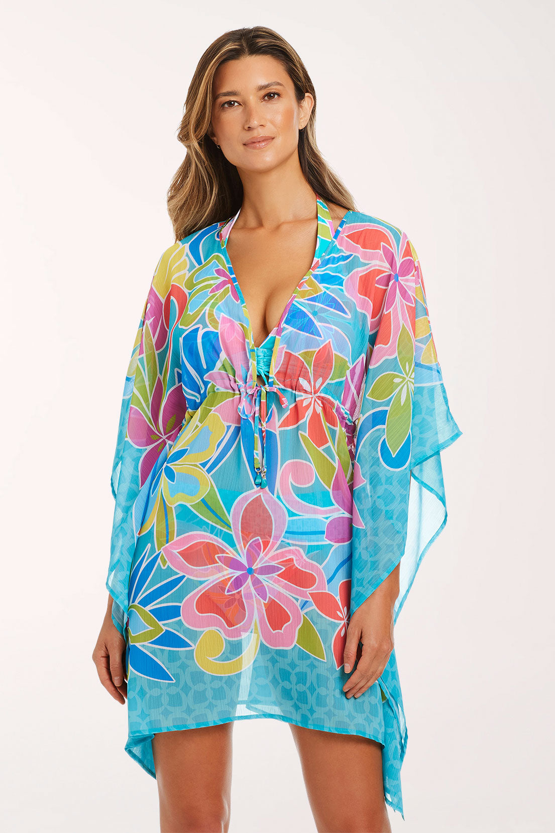 Front view of the Barcelona Bloom Chiffon Caftan in a turquoise tropical floral print with coral, pink, lime green and blue flowers, showing the deep V-neck, beaded drawstring waist, flowing kimono sleeves and mid-thigh length with a turquoise geometric border.