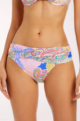 Close-up front view of the La Vida Bohemia Sarong Hipster Bikini Bottom in a paisley patchwork print in pink, lavender, lime green, coral and cobalt blue, with a wide wrapped sarong-style waistband and full-coverage cut.