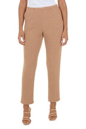 Beige fleece lounge pants worn by a person on a white background.