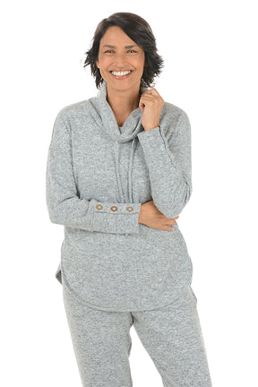 Woman wearing a grey hoodie with button details on the arm on a white background.