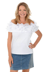 Woman wearing a white off-shoulder top with ruffles and a denim skirt on a white background