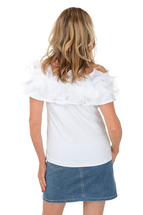 Woman wearing a white top with ruffled shoulders and a denim skirt on a white background