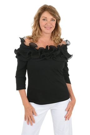 Woman wearing a black off-shoulder top with ruffles on a white background.