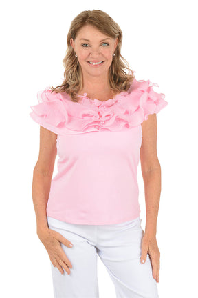 Woman wearing a pink blouse with ruffled sleeves on a white background