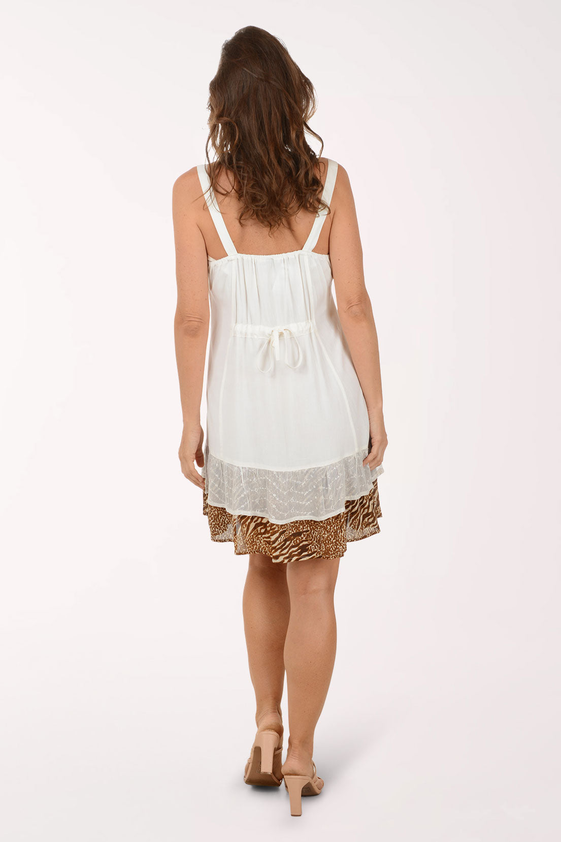 Woman wearing a white dress with gold accents on a white background