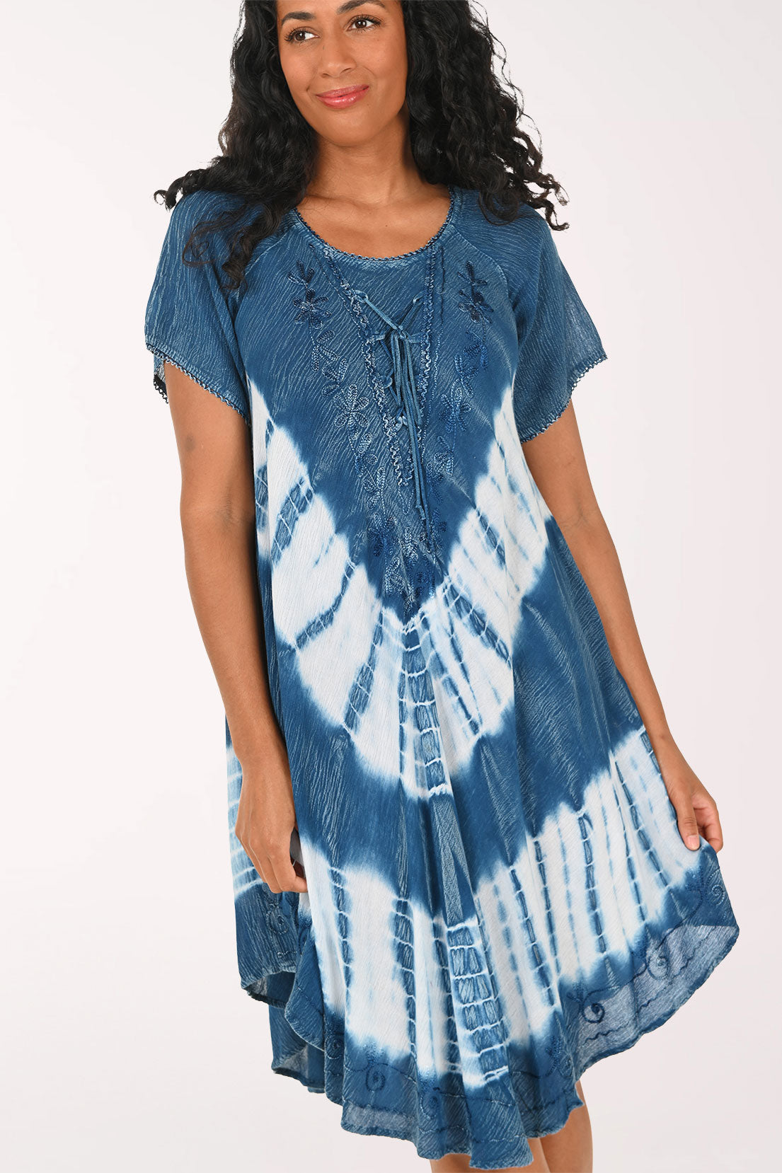 Woman wearing a blue and white tie-dye dress on a white background