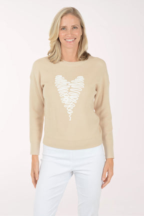 Woman wearing a beige sweater with a white heart design on a white background