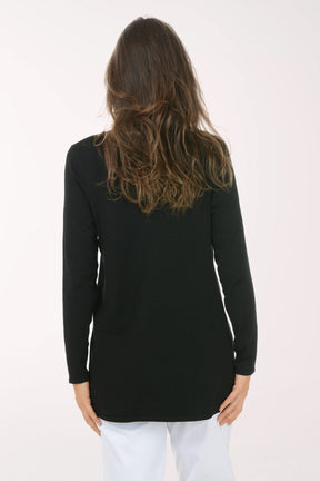 Woman wearing a black cardigan over a white top on a white background. Back shot.