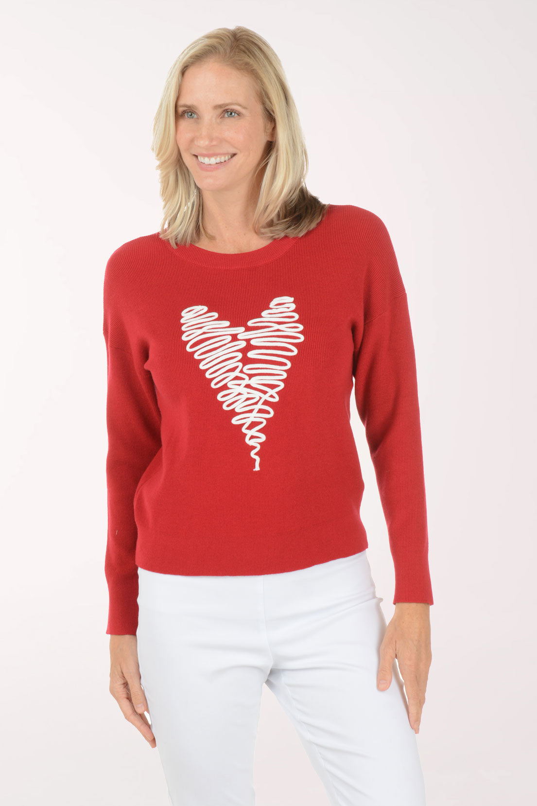 Woman wearing a red sweater with a white heart design on a white background