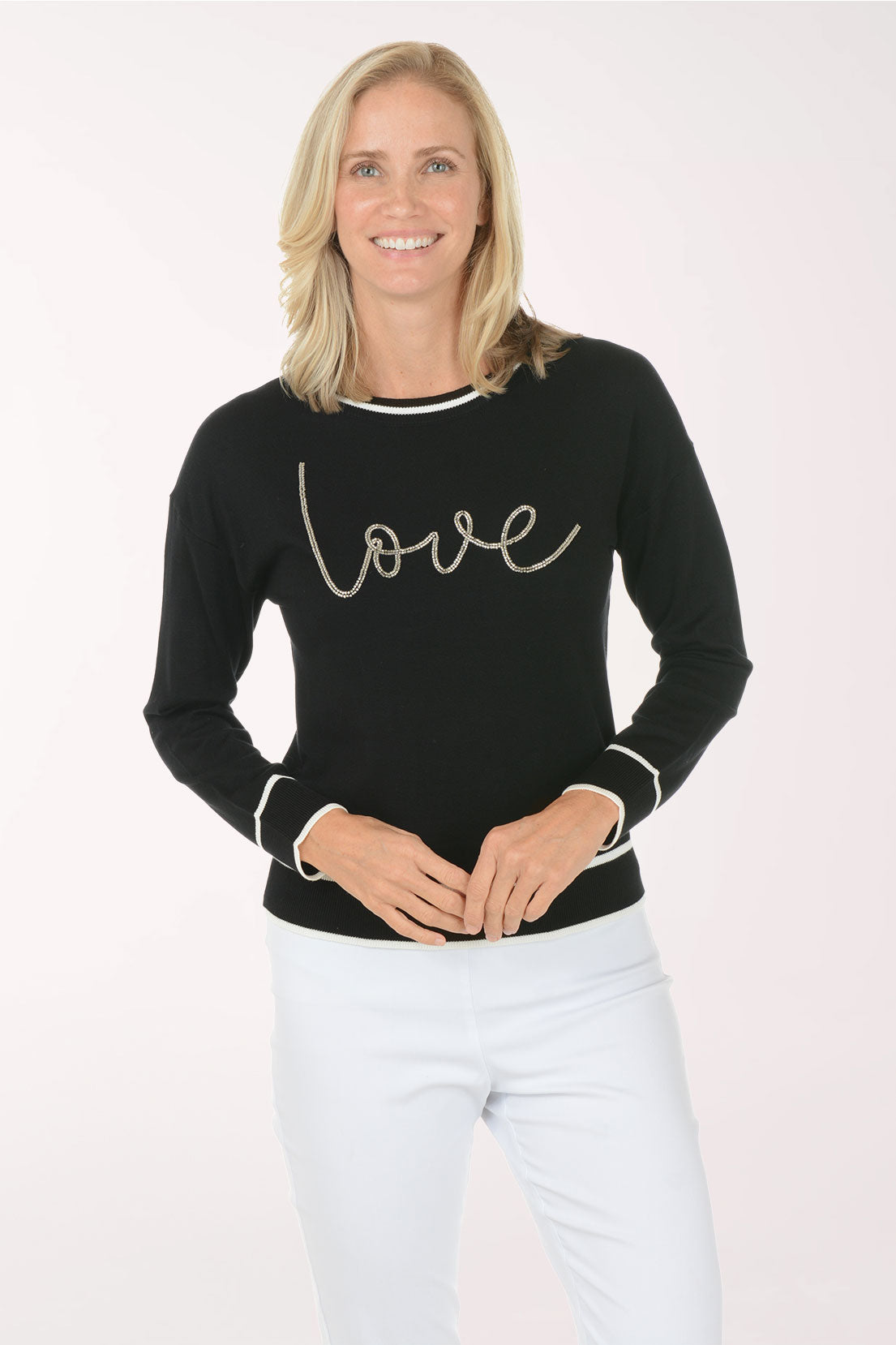 Woman wearing a black sweater with 'love' text on a white background