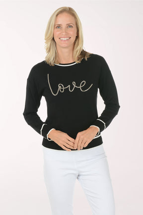 Woman wearing a black sweater with 'love' text on a white background