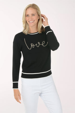 Woman wearing a black sweater with 'love' text on a white background