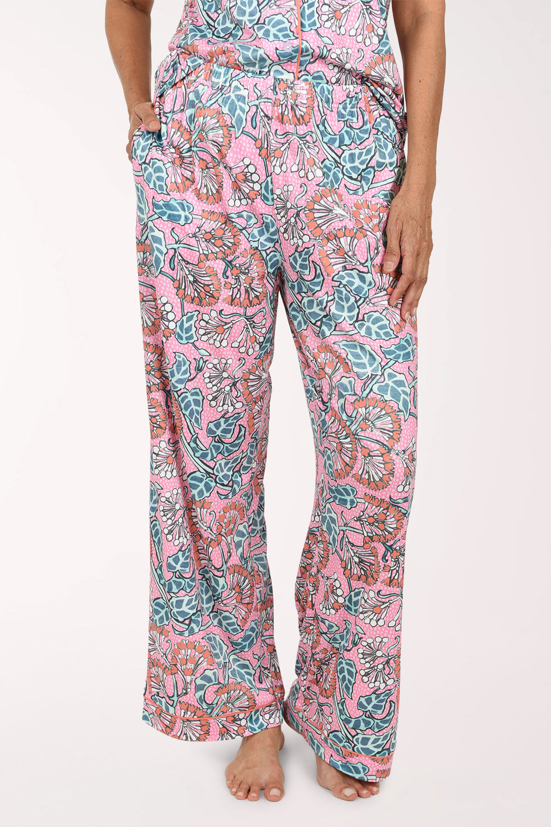 Pink wide-leg pants with a colorful floral and paisley print, shown on a model from the waist down against a plain white background.