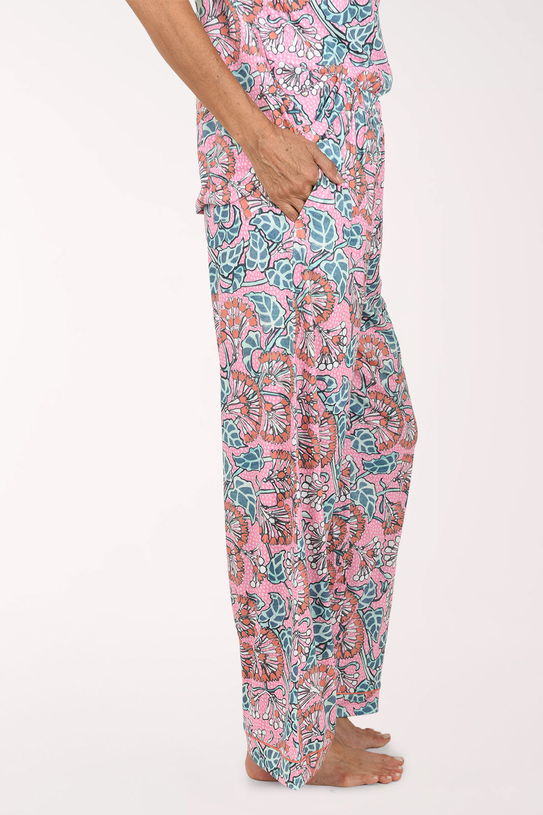 Pink wide-leg pants with a colorful floral and paisley print, shown on a model from the waist down against a plain white background.