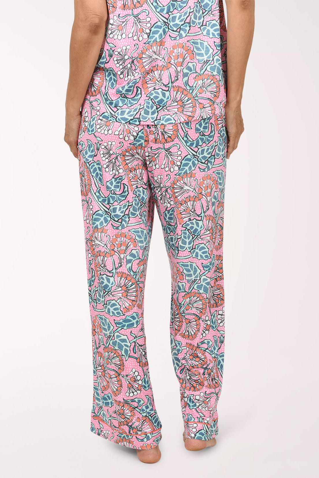 Pink wide-leg pants with a colorful floral and paisley print, shown on a model from the waist down against a plain white background.