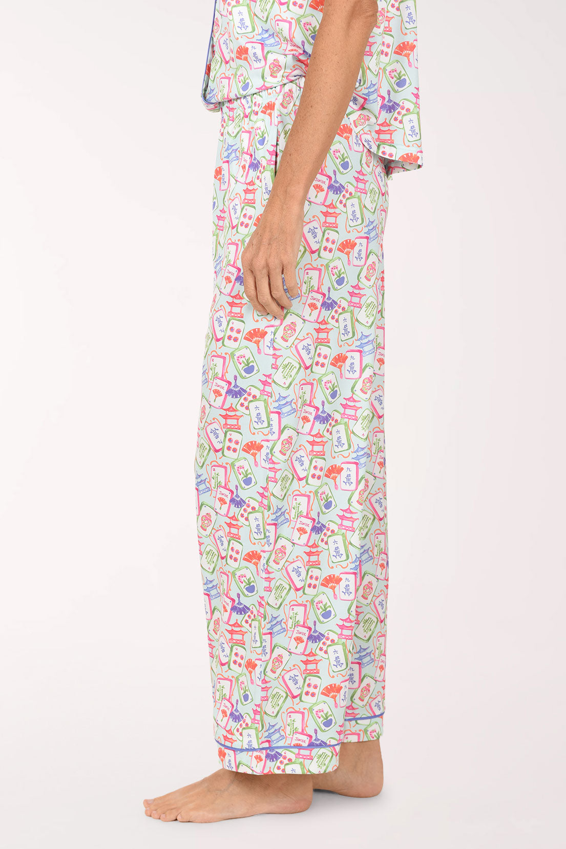 A person wearing a matching pajama set with a colorful abstract print, shown from the waist down against a plain light background.