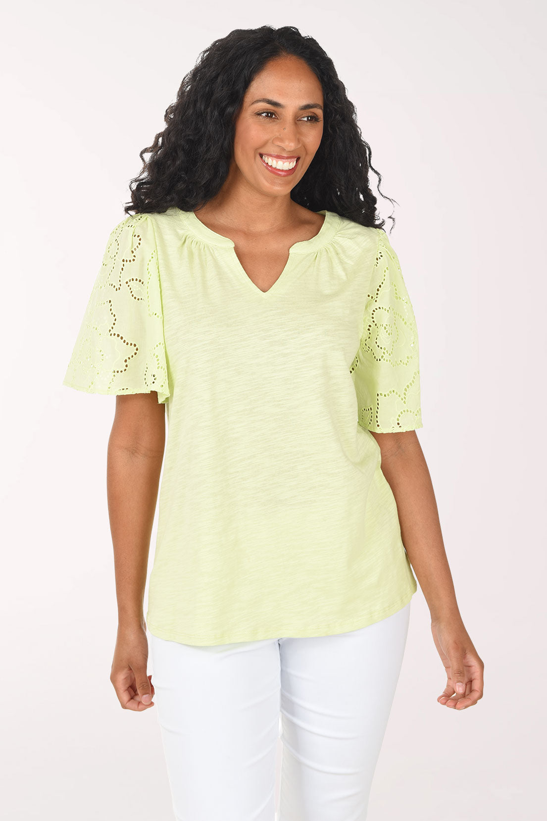 Woman wearing a light green blouse with lace sleeves on a white background