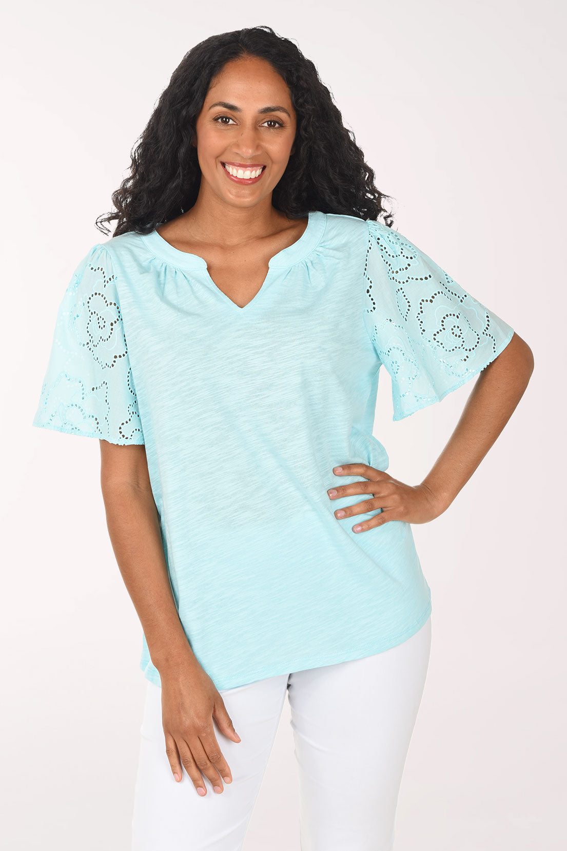 Woman wearing a light blue blouse with lace details on a white background