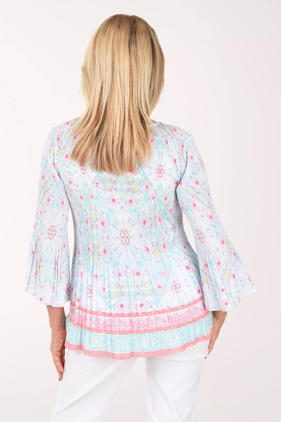 Woman wearing a light blue floral print top with pink trim on a white background