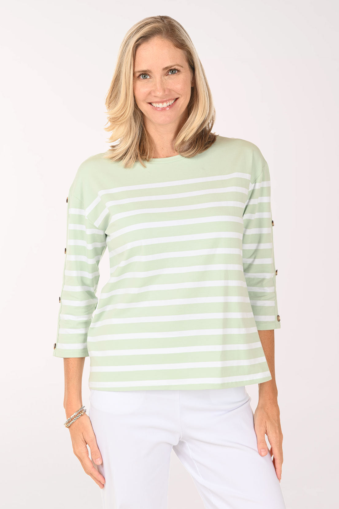 Woman wearing a 3/4 sleeve light green and white striped top.