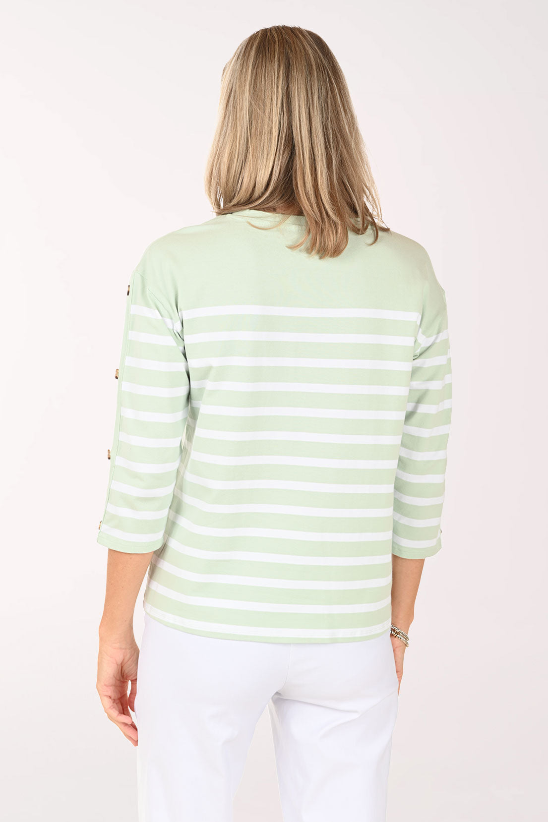 Woman wearing a 3/4 sleeve light green and white striped top.