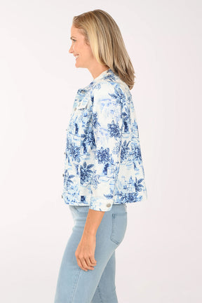 Woman wearing a white denim jacket with a blue floral pattern.
