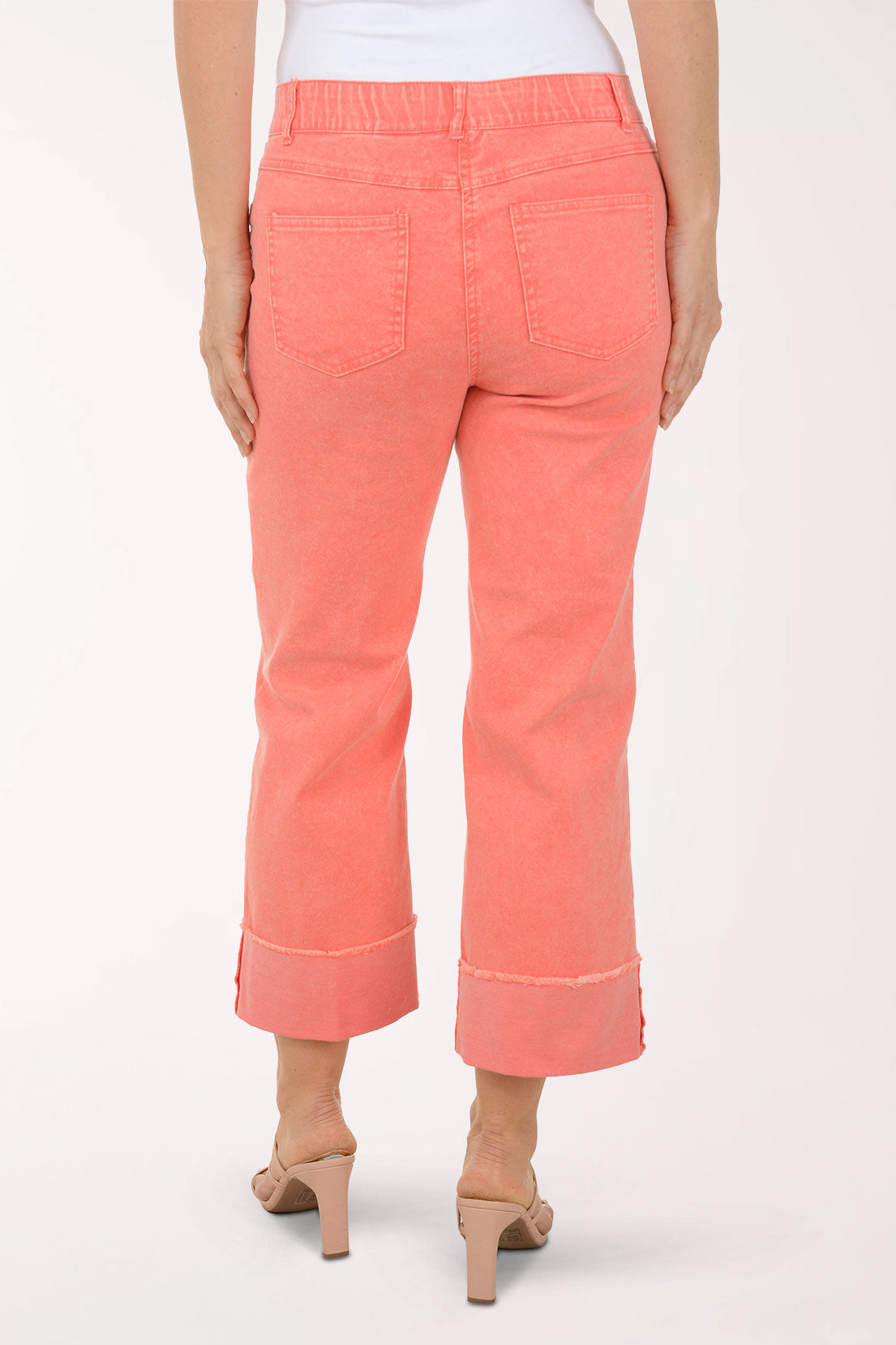 Coral pants worn by a person on a white background