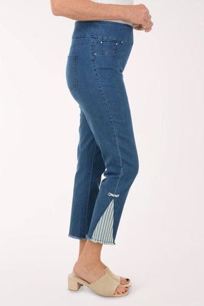 Woman wearing a blue patterned top and blue pants on a white background