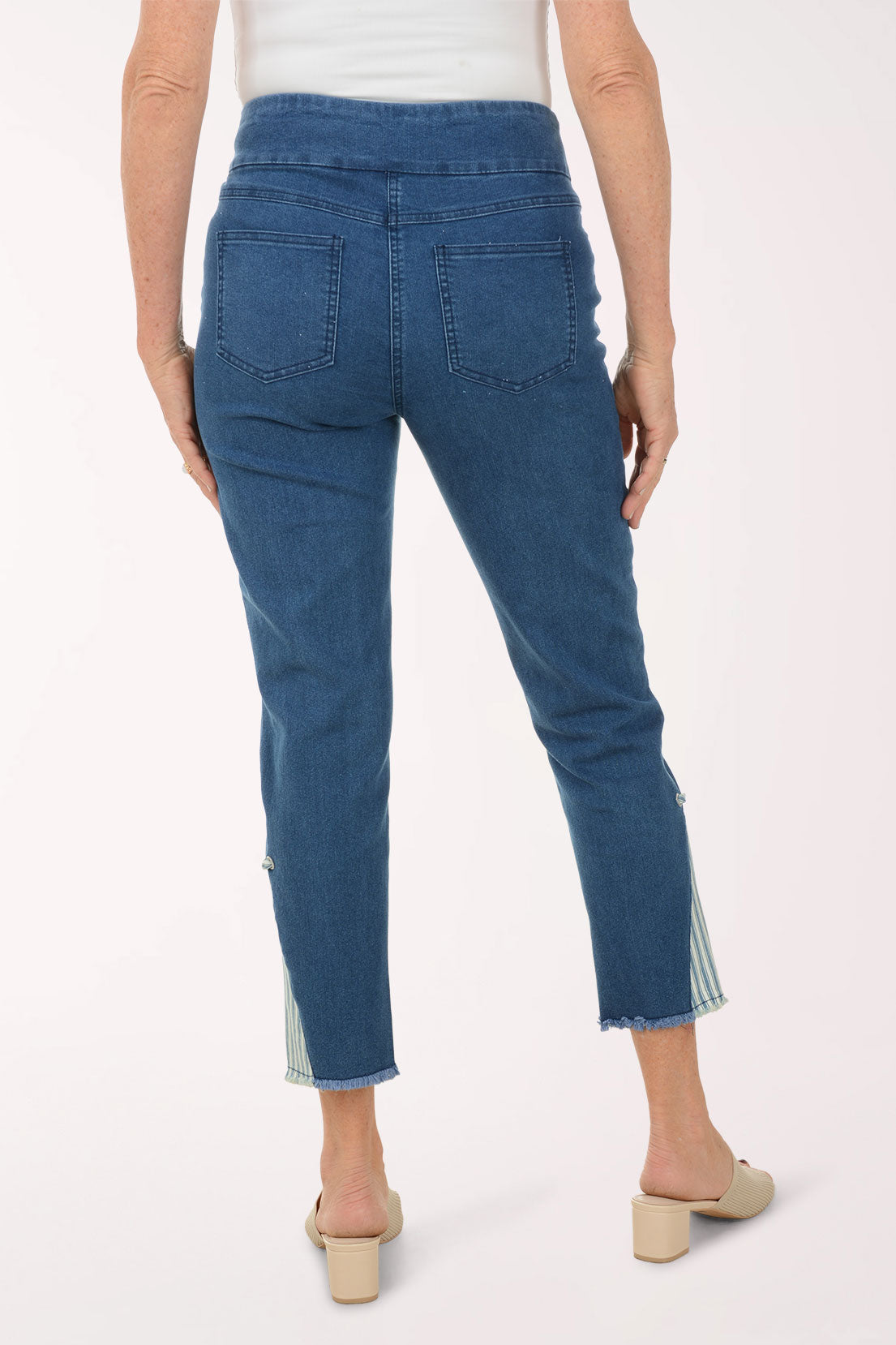 Woman wearing a blue patterned top and blue pants on a white background