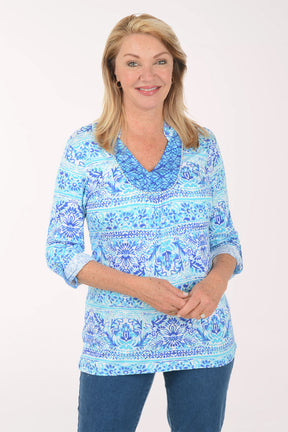 Woman wearing a blue patterned blouse on a white background