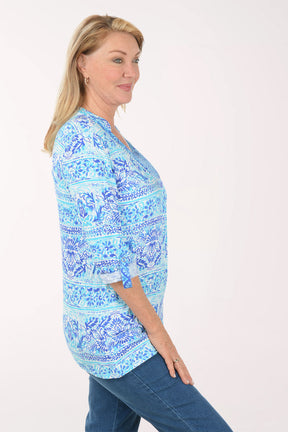 Woman wearing a blue patterned blouse on a white background