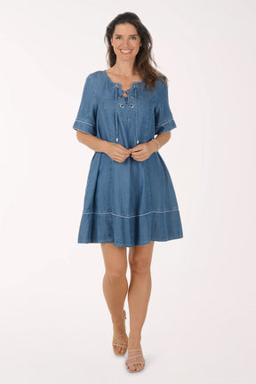 Woman wearing a blue denim dress on a white background