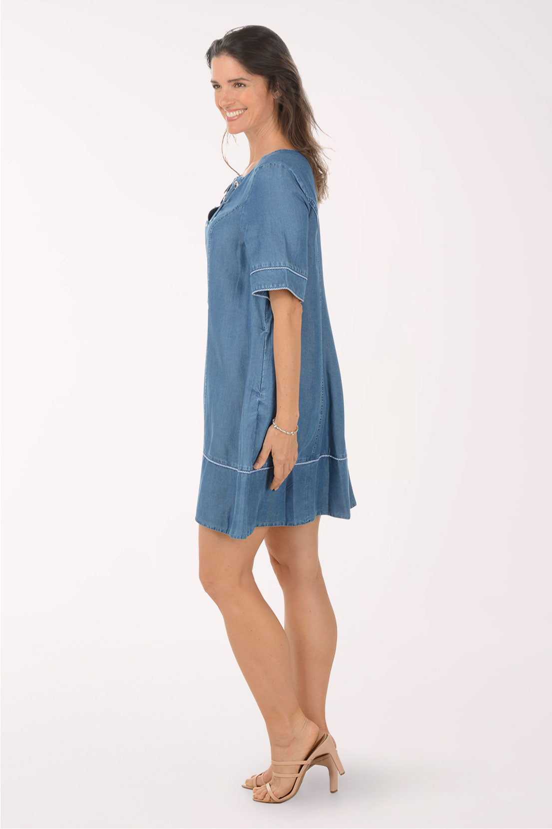 Woman wearing a blue denim dress on a white background