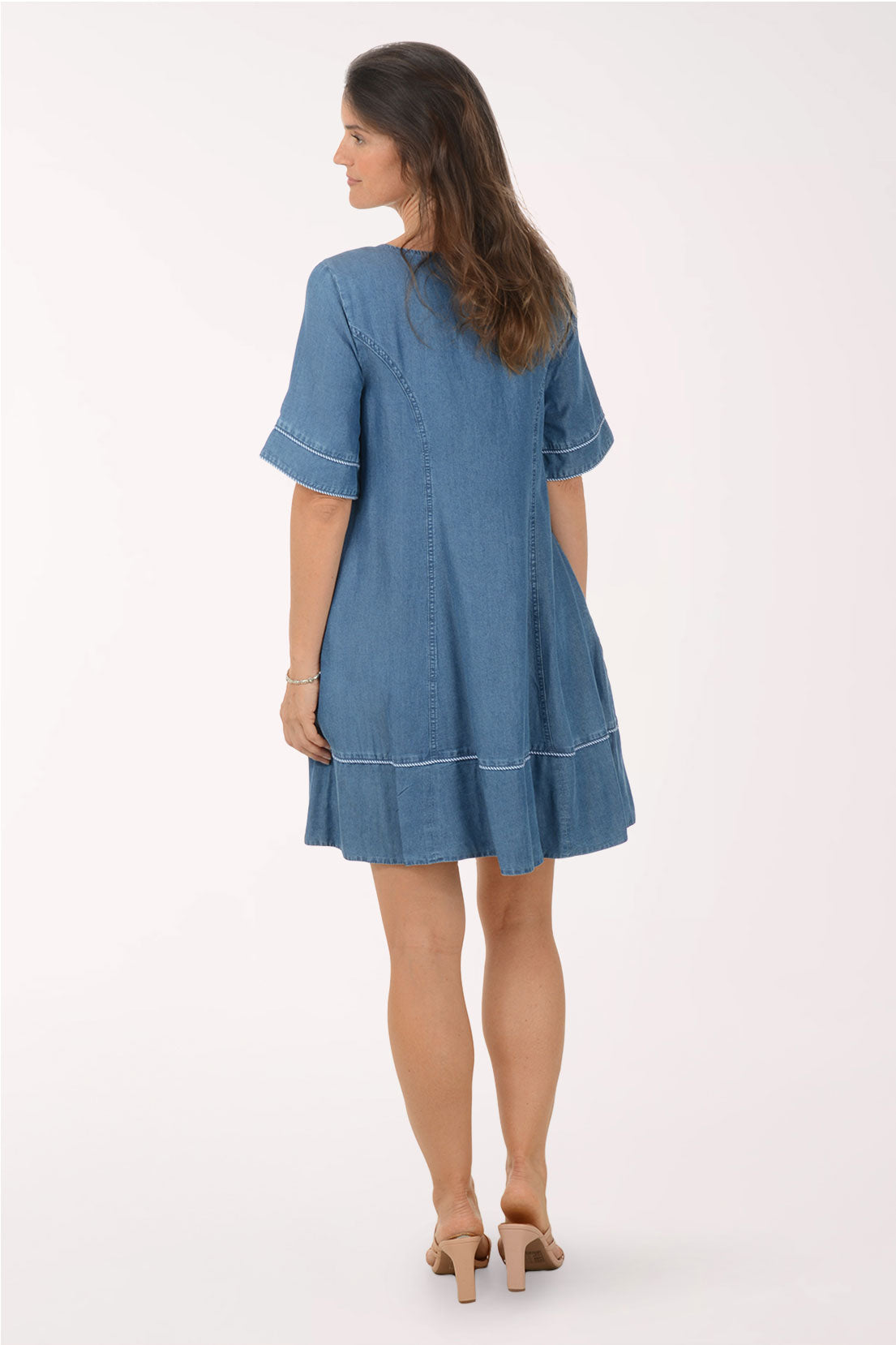Woman wearing a blue denim dress on a white background