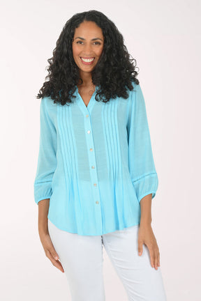 Woman wearing a light blue blouse with a white background