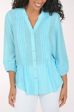 Woman wearing a light blue blouse with a white background