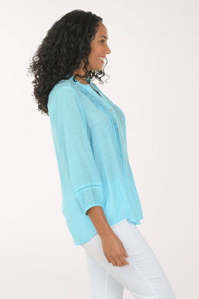 Woman wearing a light blue blouse with a white background