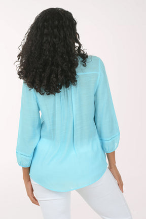 Woman wearing a light blue blouse with a white background