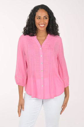 Woman wearing a pink blouse and white pants on a white background