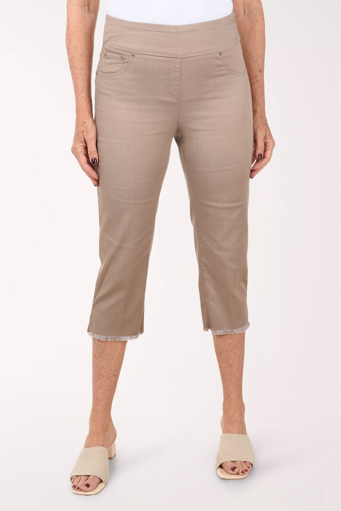 Beige capri pants worn by a person on a white background