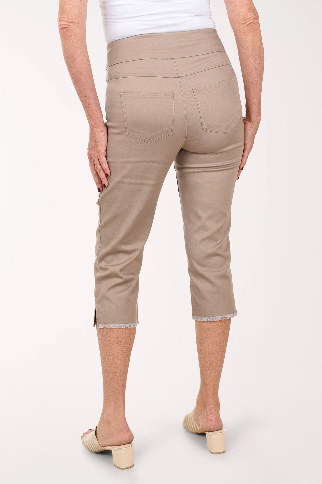 Beige capri pants worn by a person on a white background